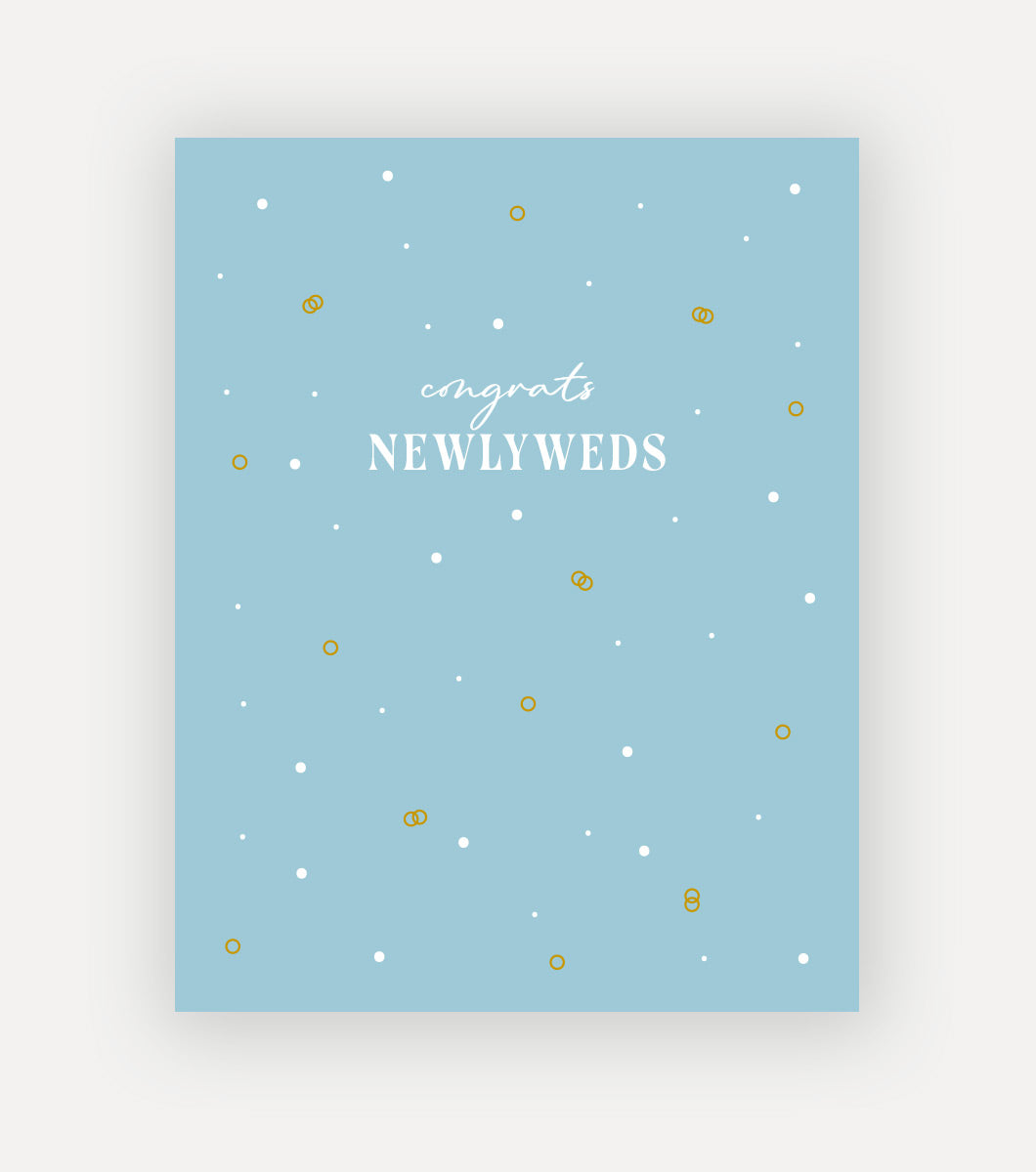 simple blue newlywed greeting card with "congrats newlweds" written across the front. around the sentiment are simple and dainty designs of wedding rings interlocked with gold foil and white foil accents