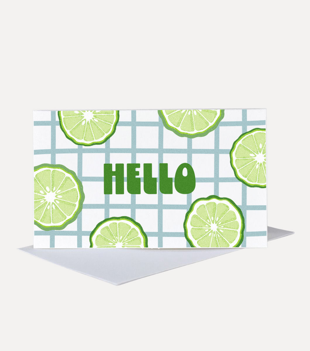 mini greeting card with message that says "hello" in retro font. design of grid checked background and sliced bergamot around the message