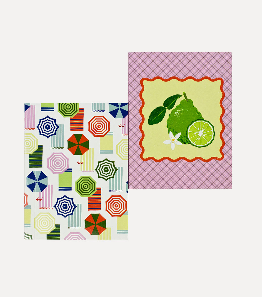 two pocket sized mini journals, one with design of sliced italian bergamot and citrus blossoms, the other with retro striped umbrella and beach towel design