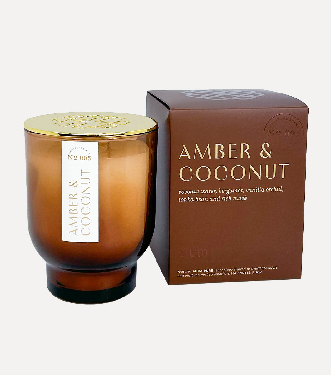 large amber and coconut scented candle pictured next to included gift box