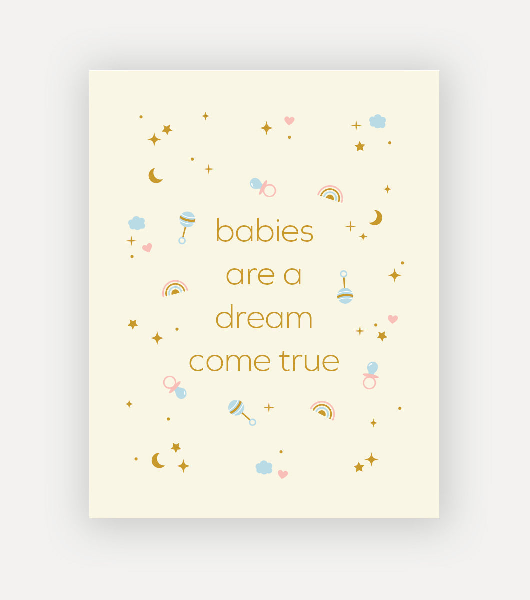 greeting card that says "babies are a dream come true" with gold foil accents of stars and moons and rattles and binkies 