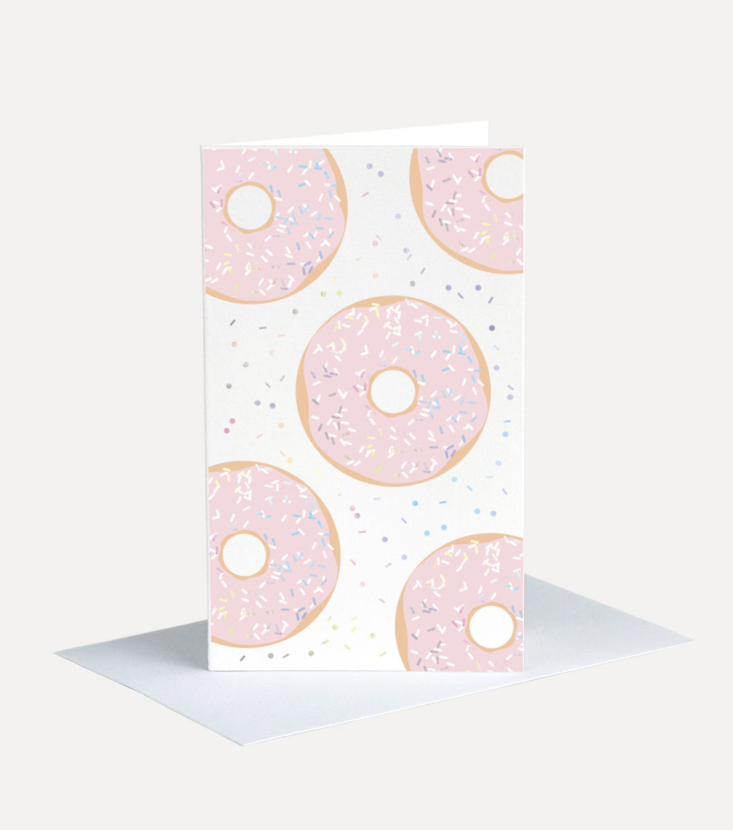 Mini greeting card with envelope. greeting card has a design of pink iced donuts with holographic sprinkles