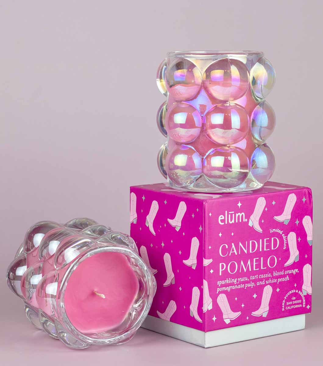 pink pony club disco cowgirl designed gift box with iridescent bubble glass candle sitting on top and the the same candle laying on its side so you can see the pink wax on the inside