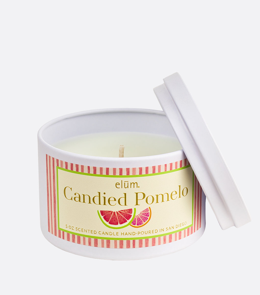 candied pomelo scented candle, white metal candle with pink striped design label 