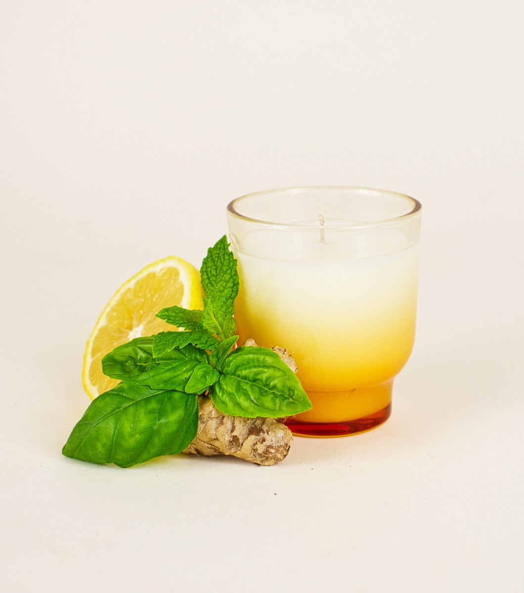 golden basil and mint candle pictured next to ginger, mint, basil and lemon