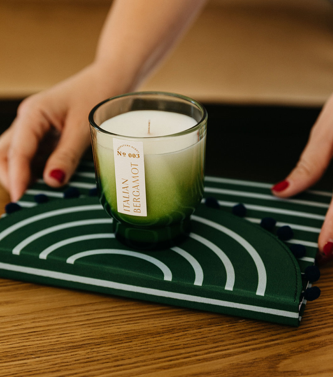 small italian bergamot scented candle resting on top of a journal