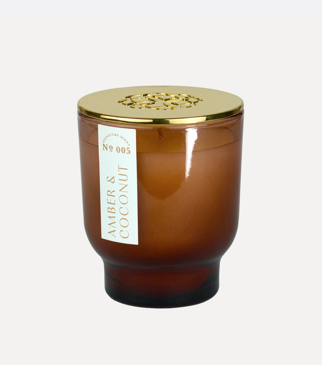 brown tapered amber and coconut scented hand poured candle from elum