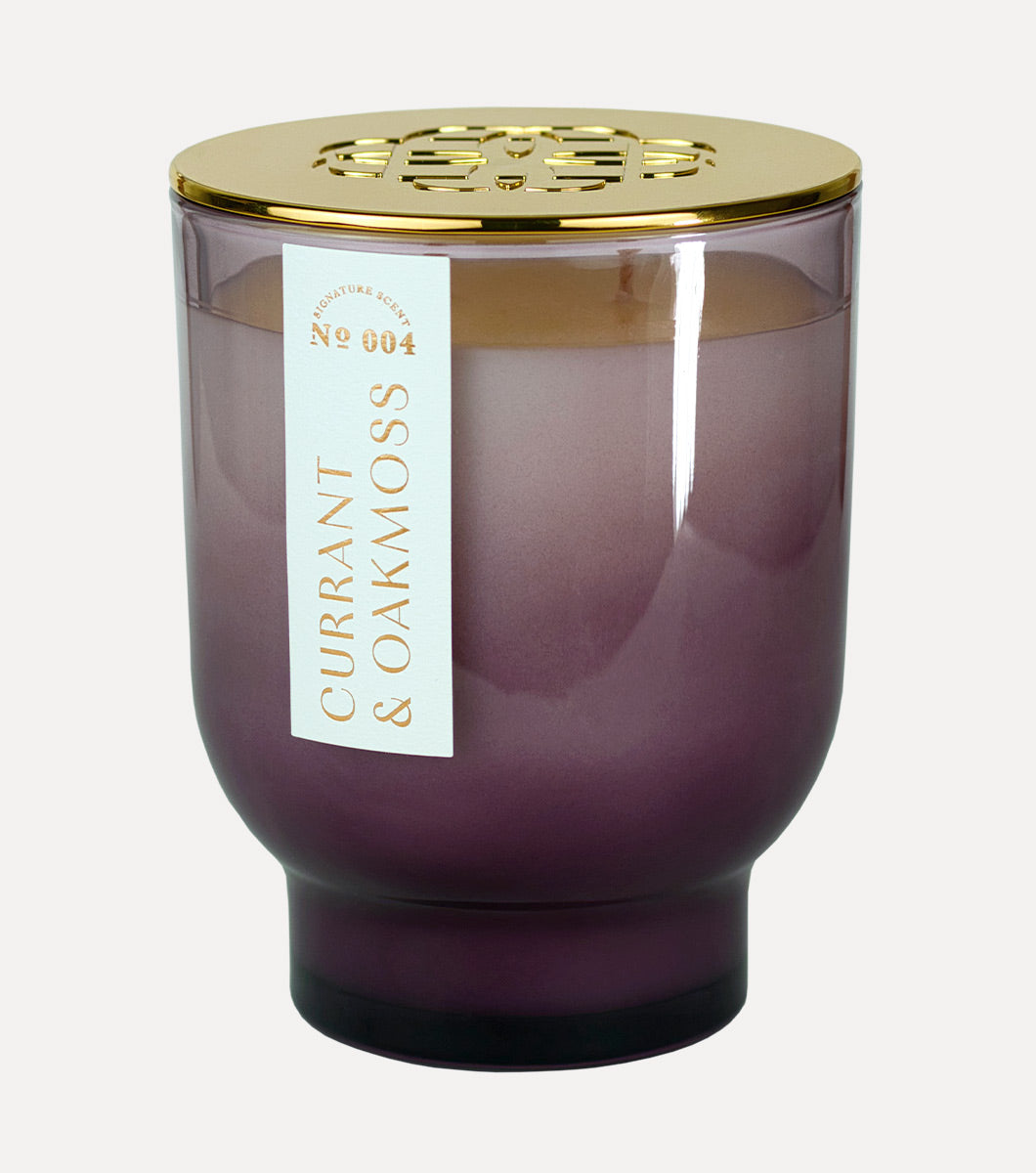 large purple tapered currant and oakmoss scetned hand poured soy wax candle with embossed gold lid