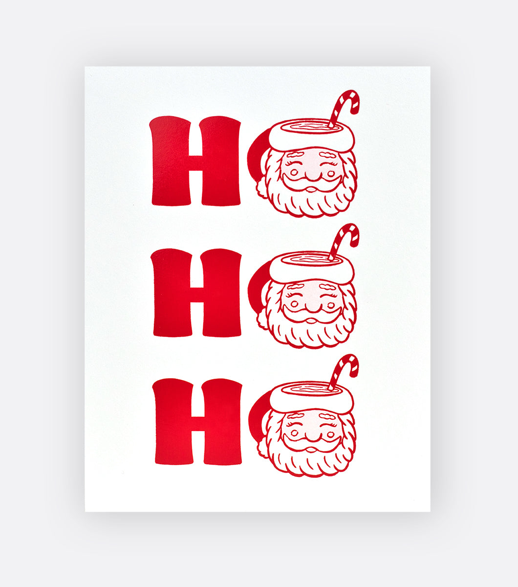 Holiday greeting card that says "HO HO HO" in red foil with the Os are santa shaped mugs with hot chocolate and a candy cane