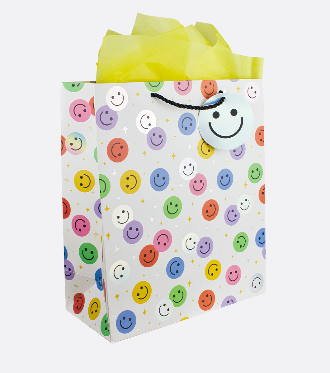 large gift bag with colorful smiley face design with holographic foil accents and yellow tissue paper