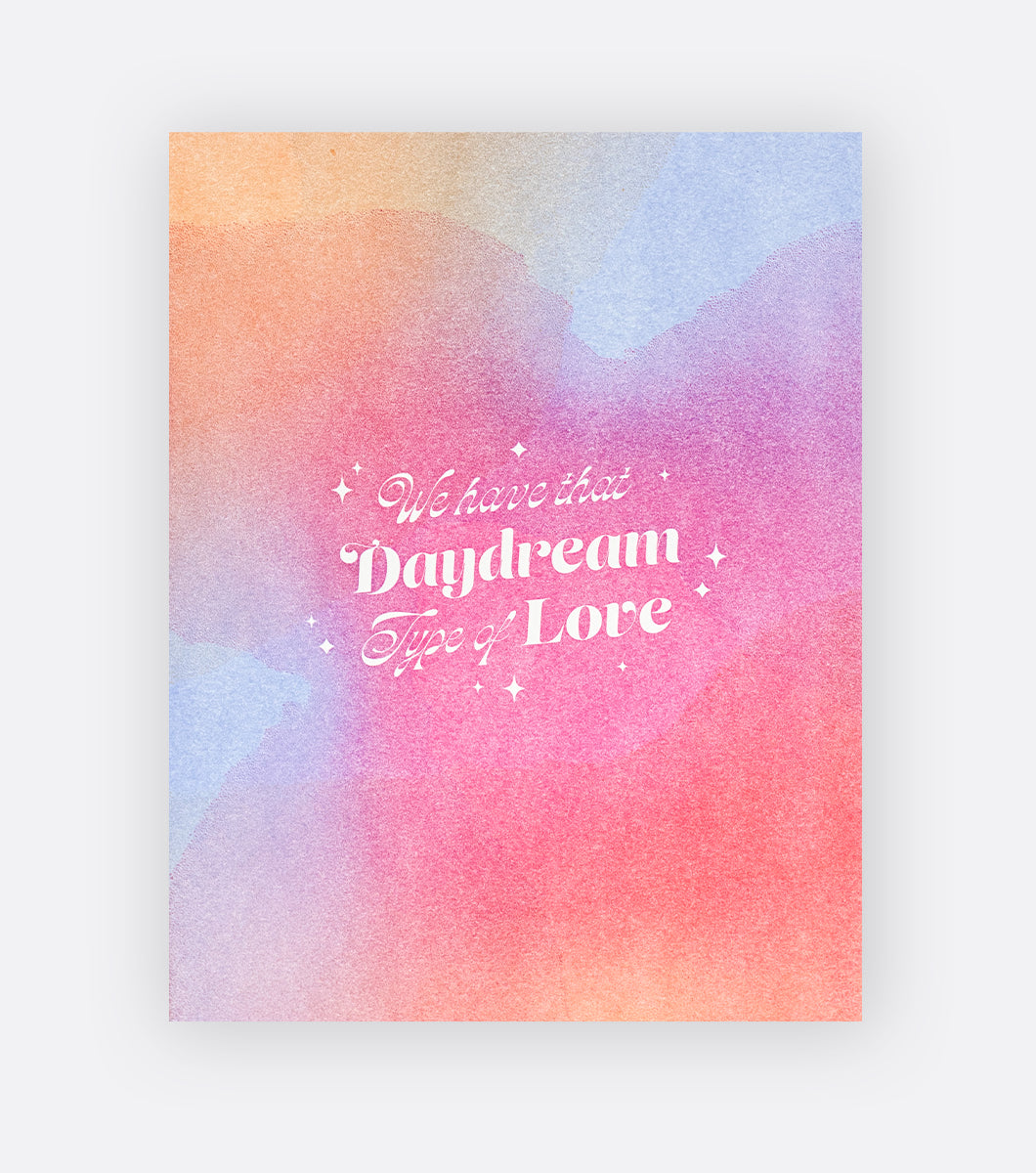 greeting card with rainbow watercolor design that says "we have that daydream type of love" reversed out in white 