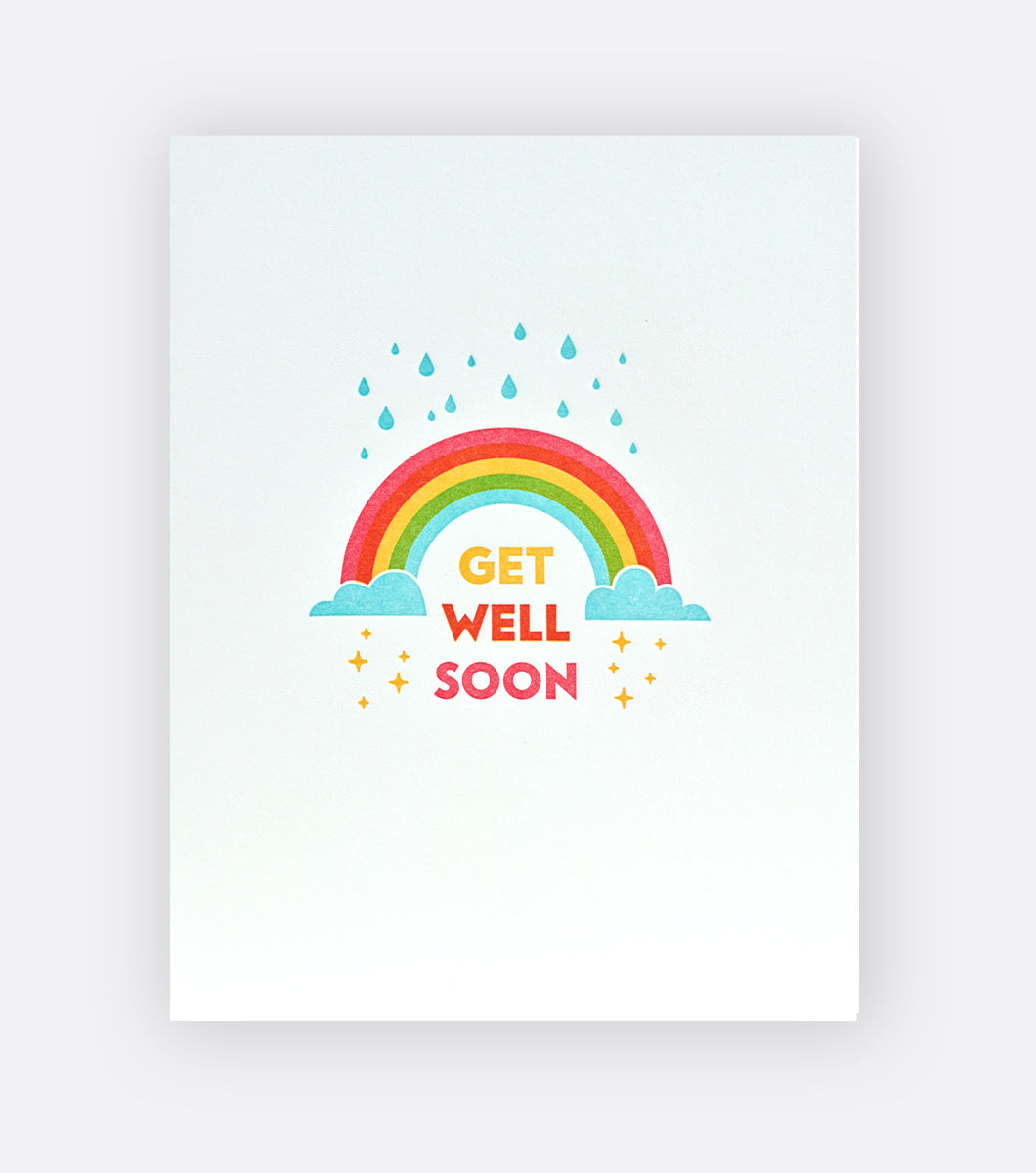 greeting card with rainbow design with raindrops that turn into sparkling stars and a sentiment that says "get well soon" on the front