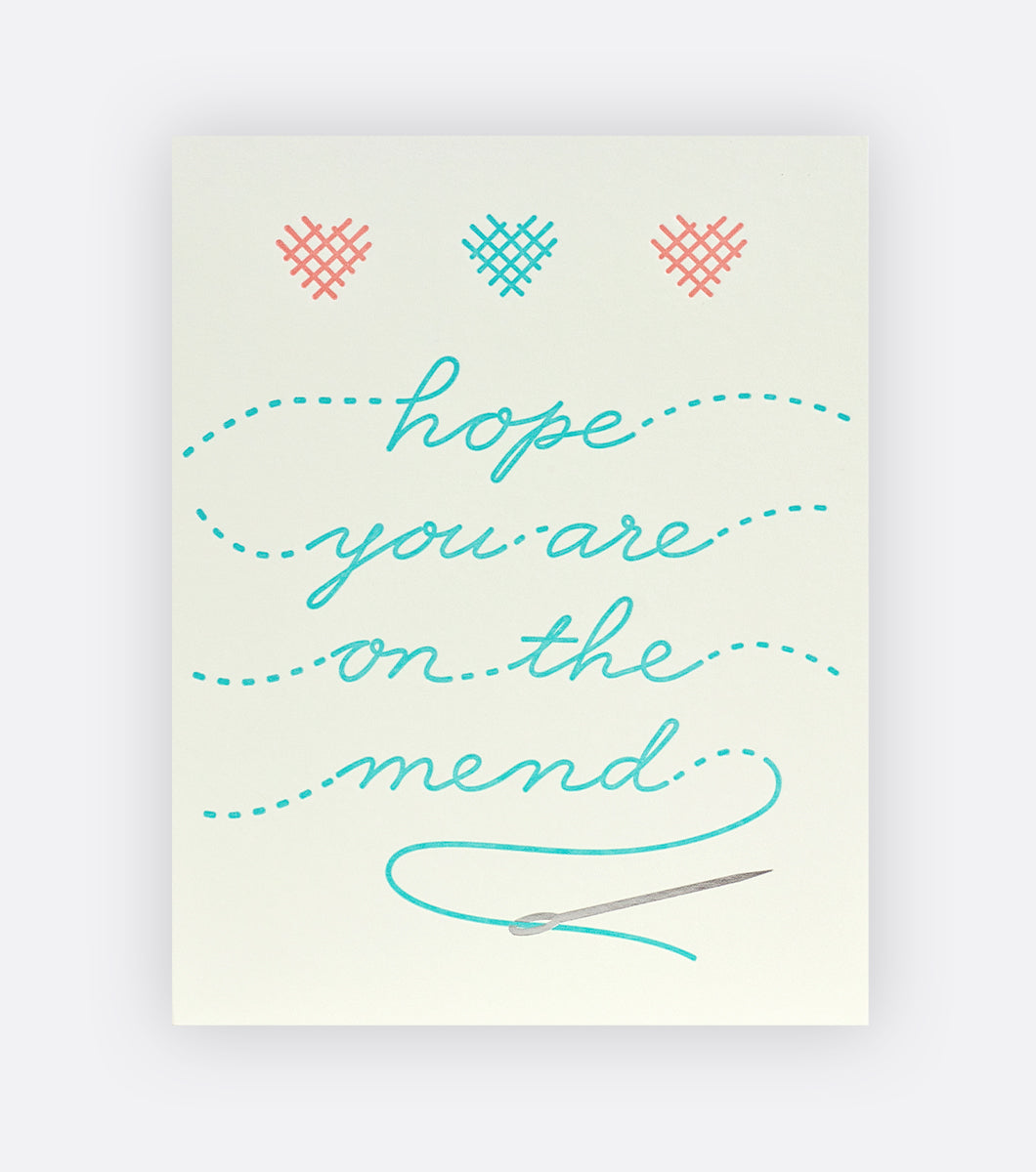 get well greeting card that says "hope you are on the mend" with cross stitched hearts and a silver foil needle 