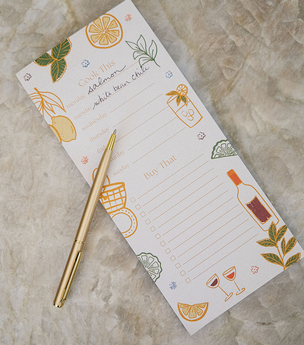 magnetic list pad with a "cook this" area for meal planning and "buy that" area for grocery lists. design features line drawings of fresh food and herbs and comes with a gold pen