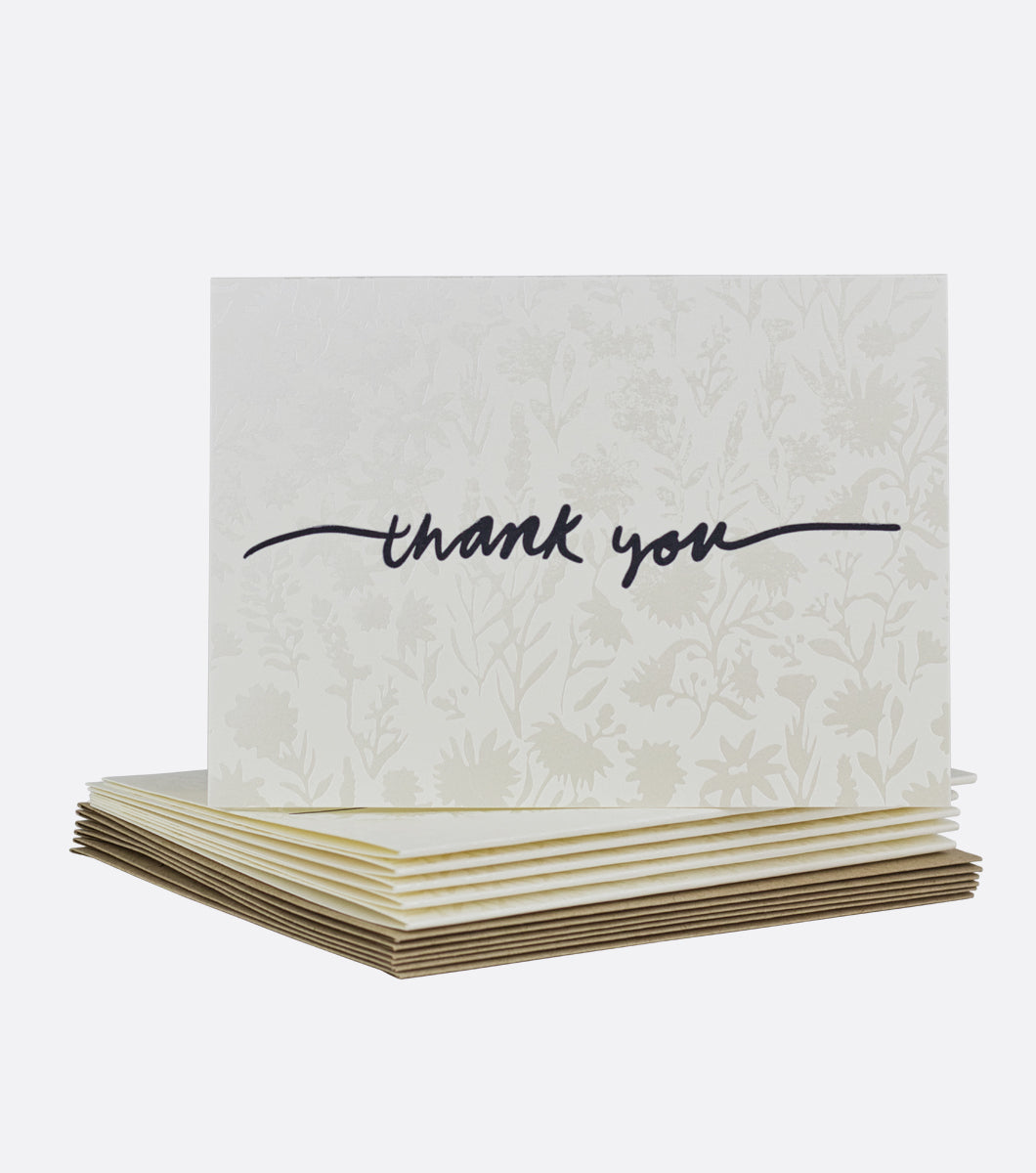 stack of wildflower thank you letterpress boxed notes with one on top. card features pearlescent floral design and thank you written on top in a black script